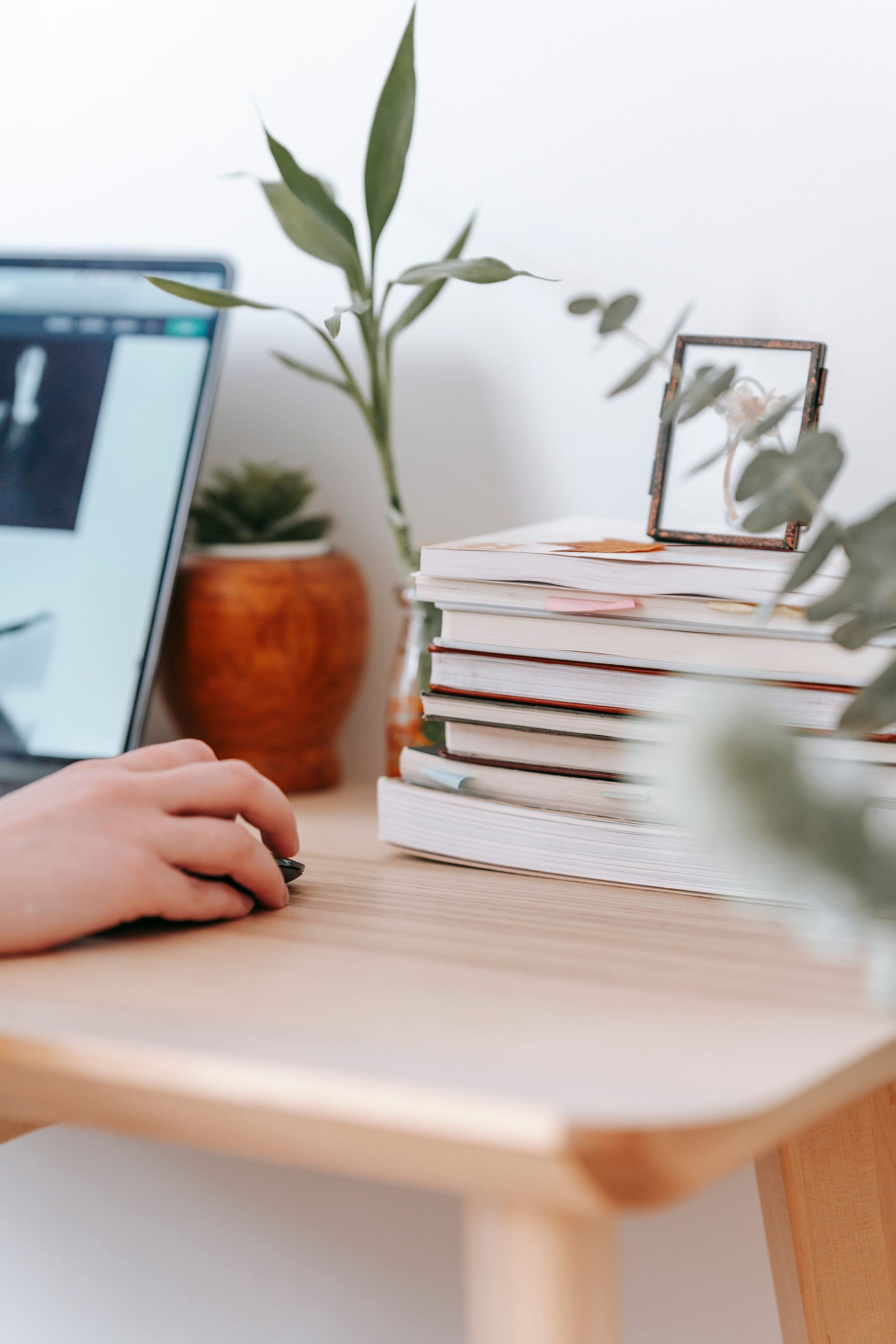 Livres ouverts et ordinateur portable sur un bureau, dans une lumière chaude