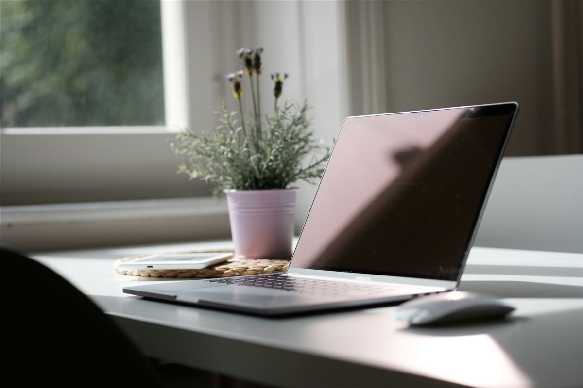 Ordinateur portable sur un bureau lumineux, à côté d'un pot de lavande